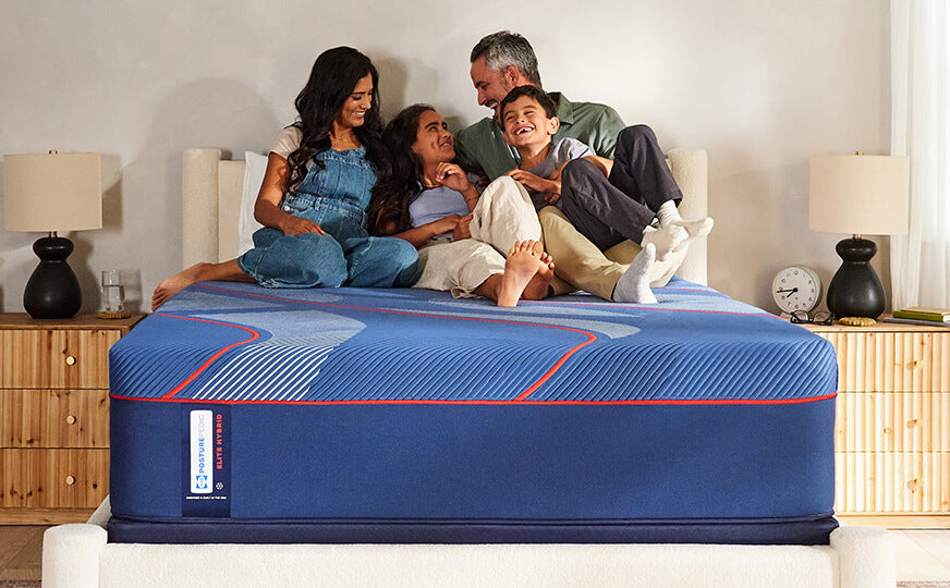 Family sitting on Sealy Posturepedic Elite Hybrid mattress
