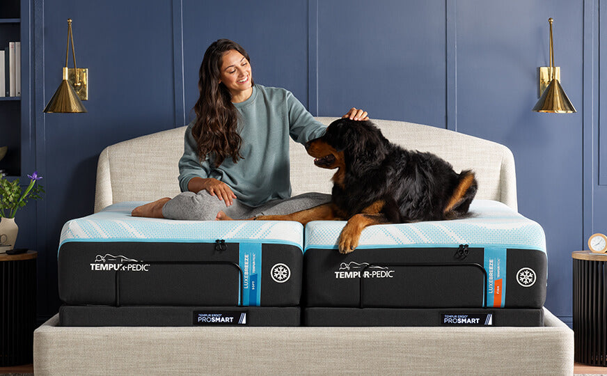 Woman and dog sitting on split queen Tempur-Pedic LuxeBreeze mattress